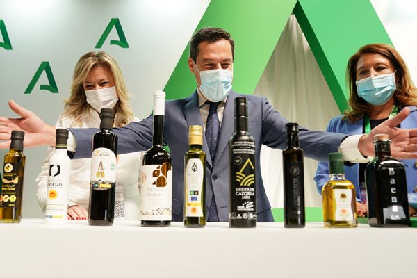 Juanma Moreno ante numerosas botellas de aceite de oliva