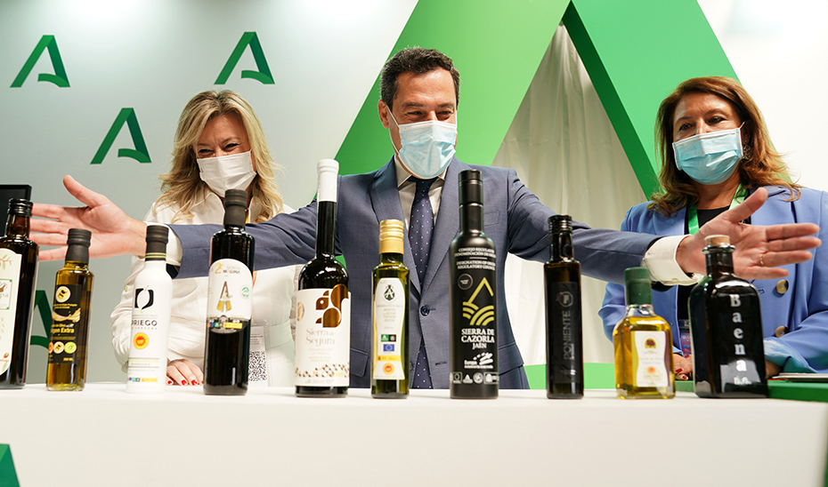 Juanma Moreno ante numerosas botellas de aceite de oliva