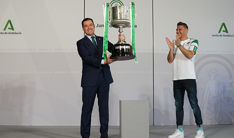 juanma moreno alza la Copa del Rey lograda por el Real Betis en 2022.